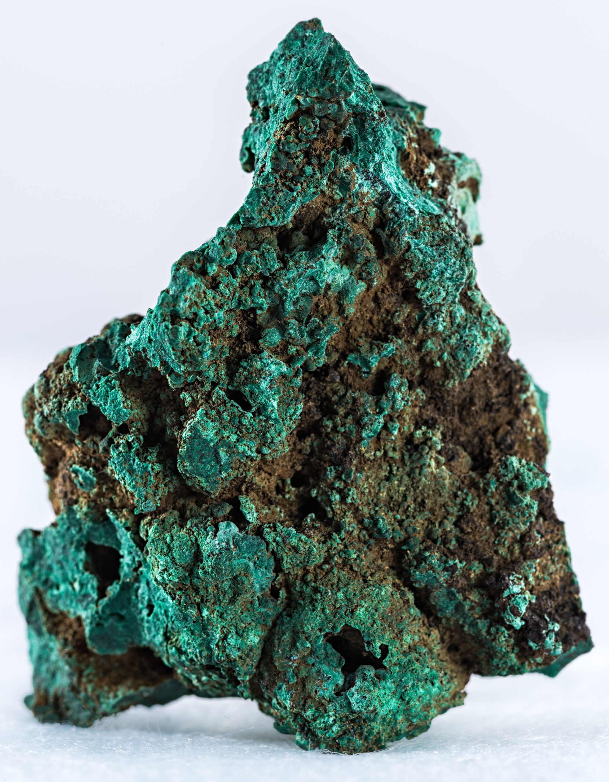 A vertical shot of a malachite mineral isolated on a white background